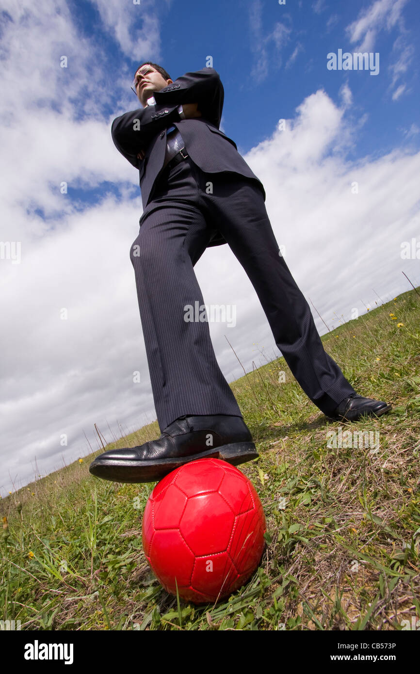 businessman holding a soccer ball in the field Stock Photo - Alamy
