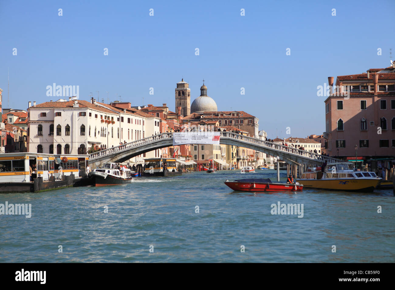 The Grand Canal, Venice, with the bridge at Ferrovia, next to the railway station with the ferry (vaporetto) stop on the left. Stock Photo