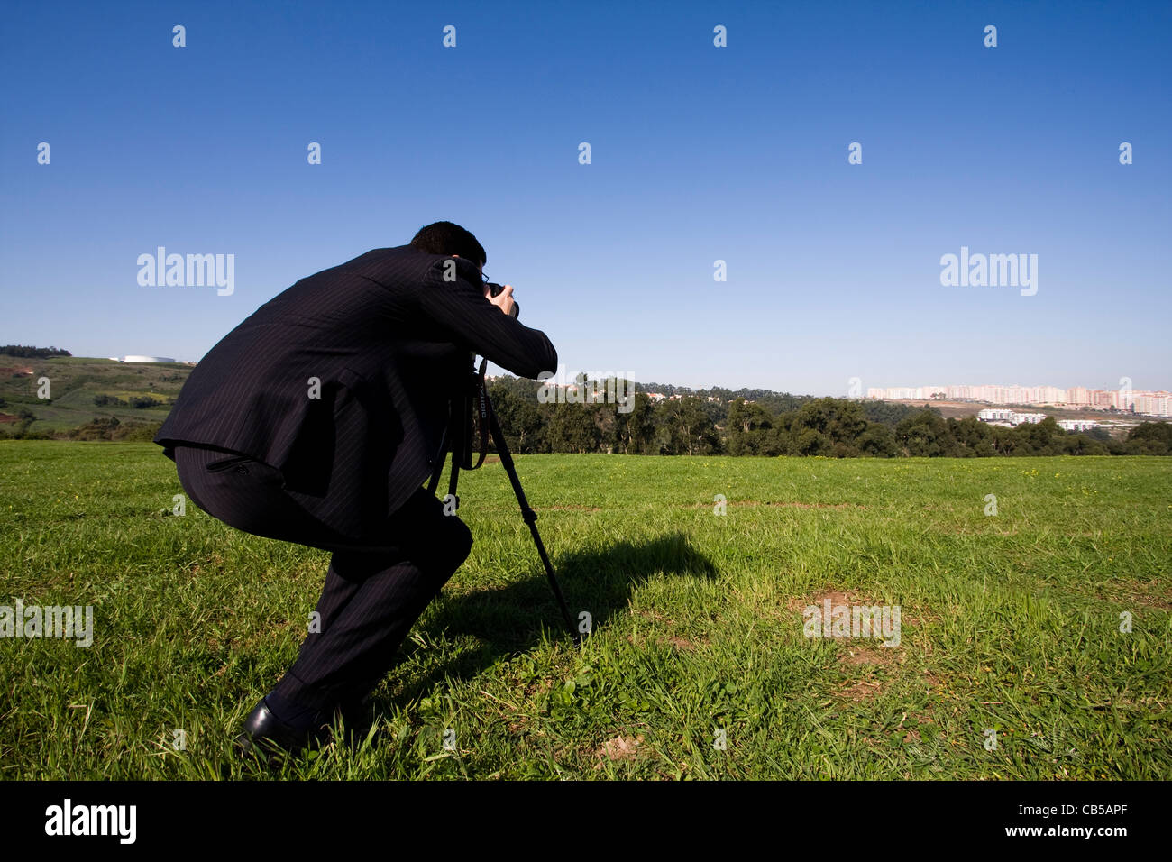 Businessman making landscape photos in a field Stock Photo - Alamy