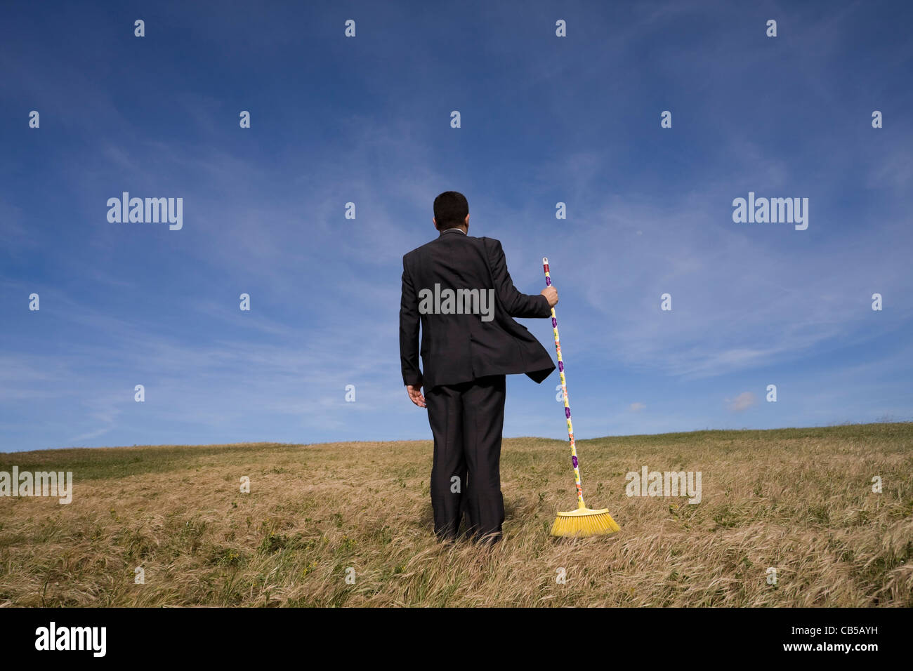 businessman cleaning the field with a broom Stock Photo Alamy