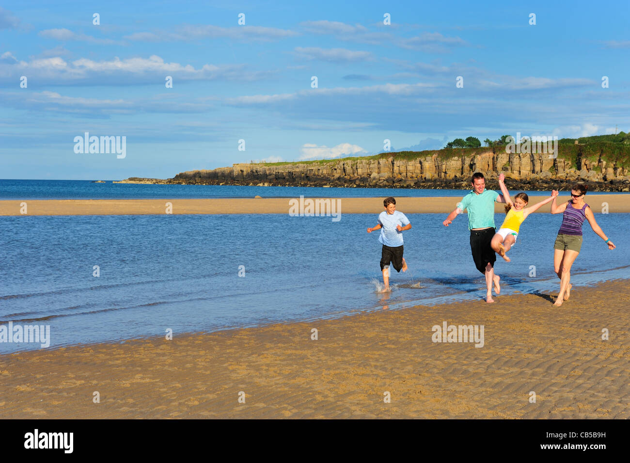 Family walking along beach hi-res stock photography and images - Alamy