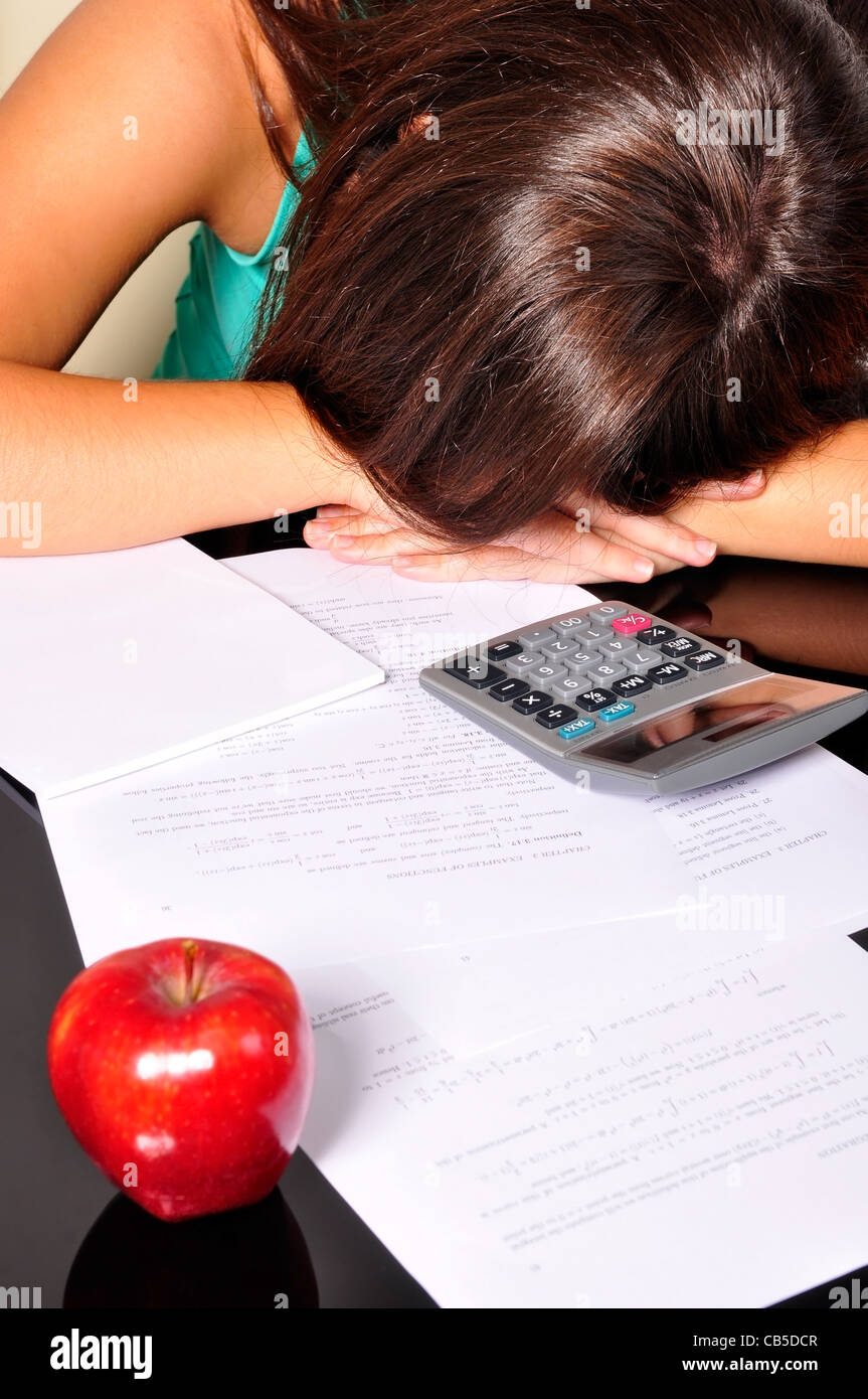 Young woman, tired of studying, sleeping over maths exercises Stock Photo