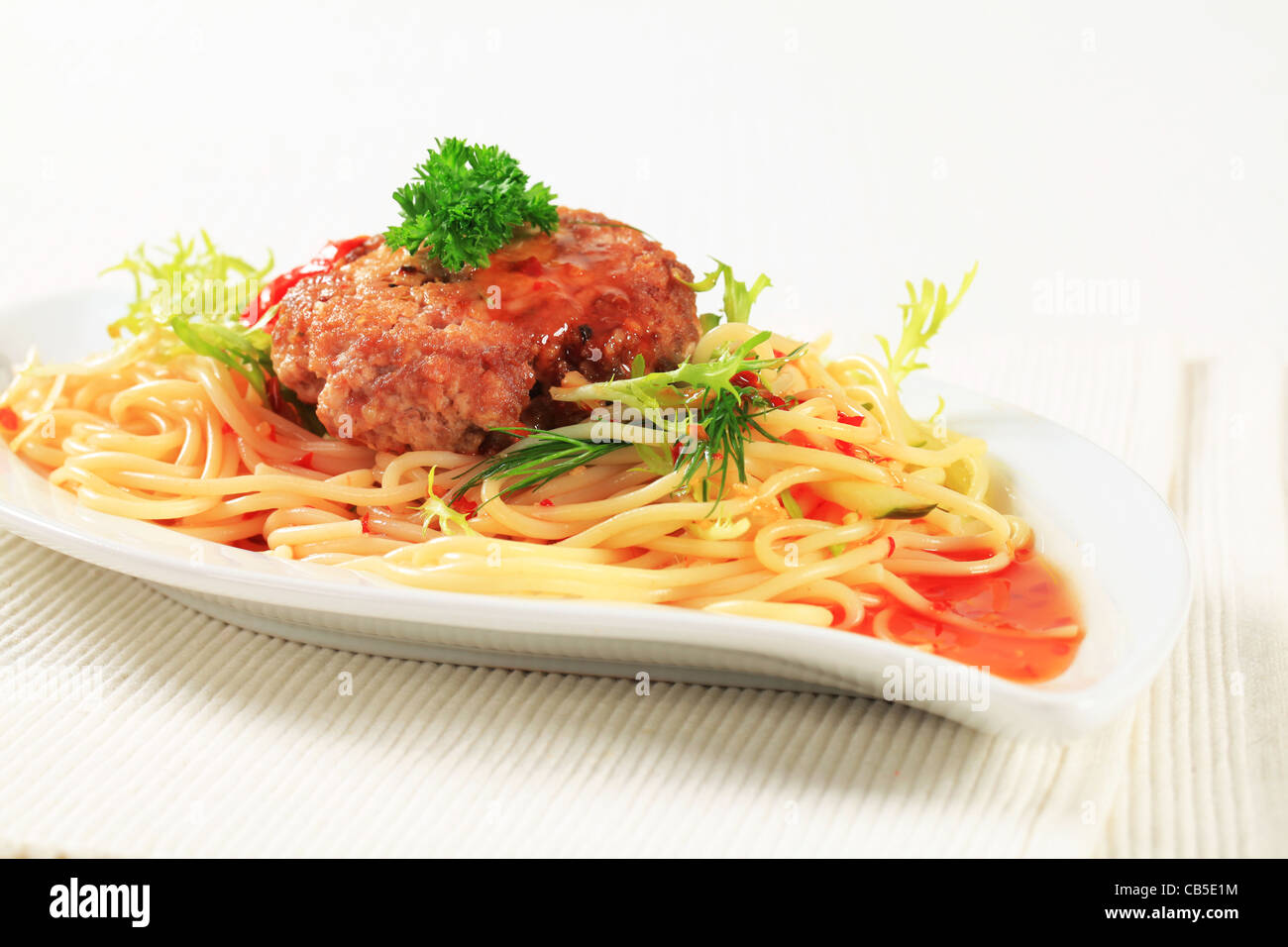Meat patty with spaghetti and spicy sauce Stock Photo