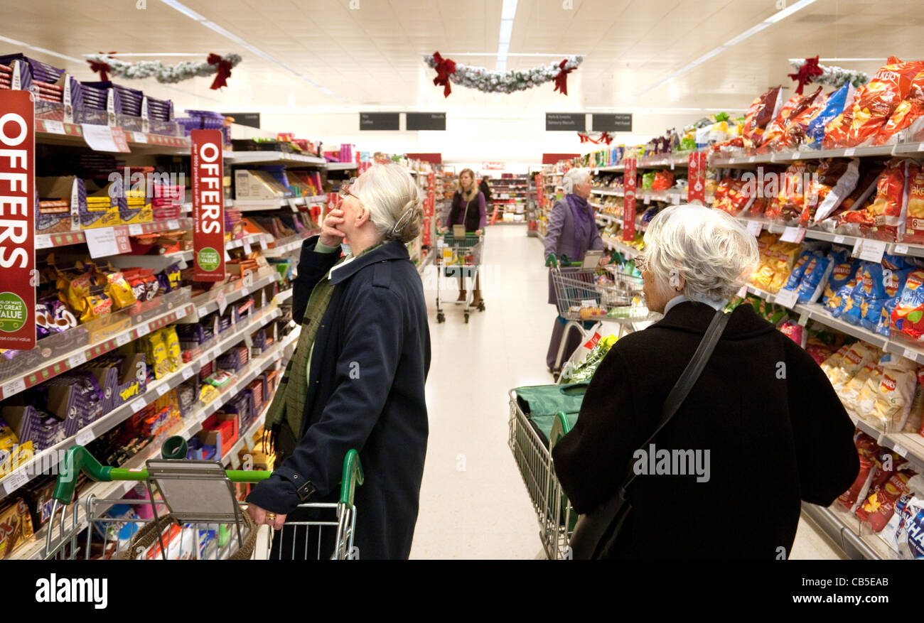 Elderly people shopping in a supermarket aisle with Offers and Stock