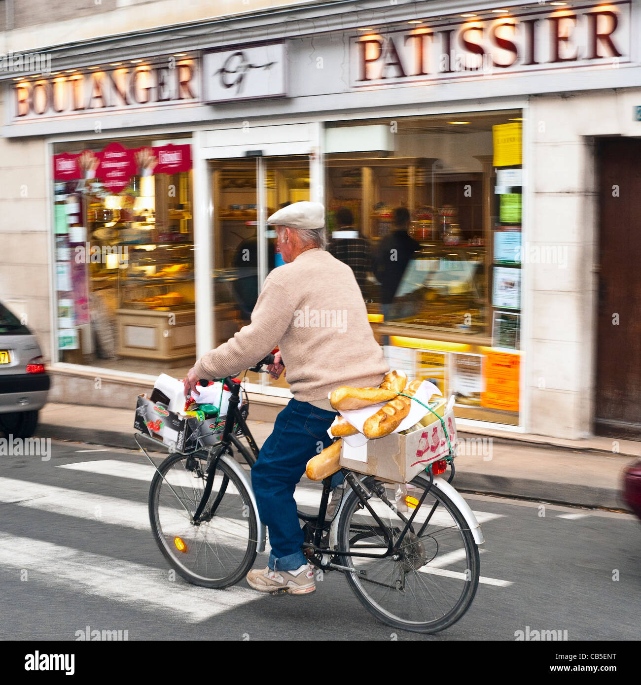 Man on bicycle with bread and shopping - France. Stock Photo