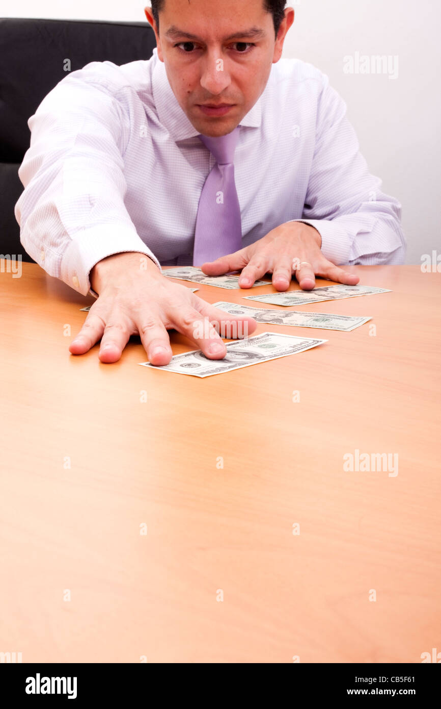 businessman grabbing a dollar bill in his desk (selective focus Stock
