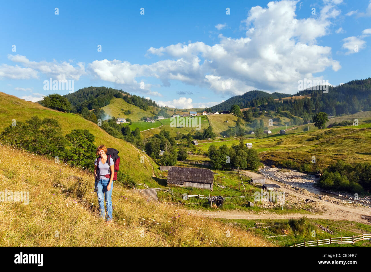 Summer mountain village landscape and woman - tourist in front Stock Photo