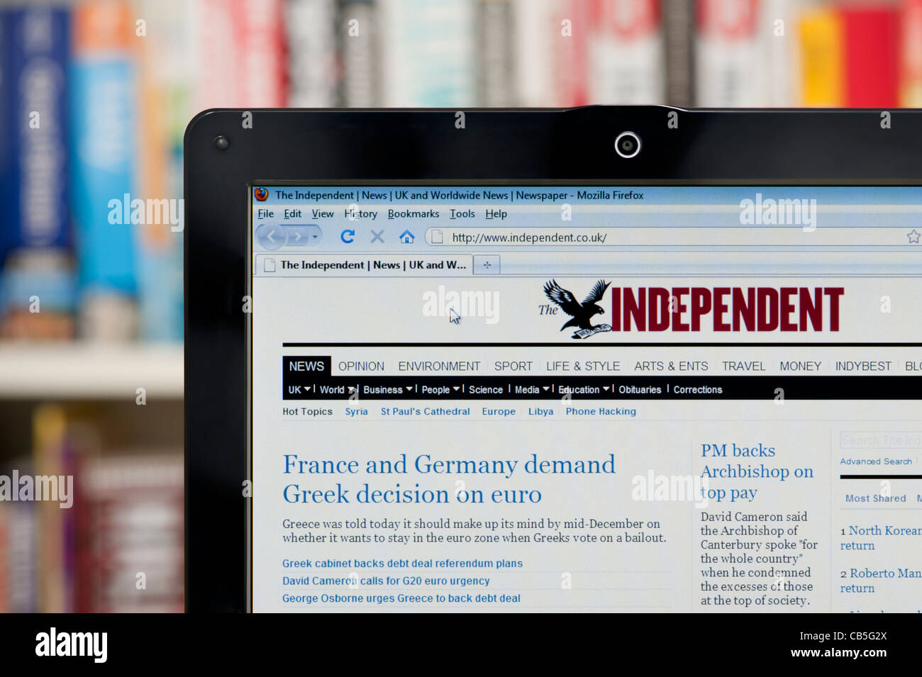 The Independent website shot against a bookcase background (Editorial use only: print, TV, e-book and editorial website). Stock Photo