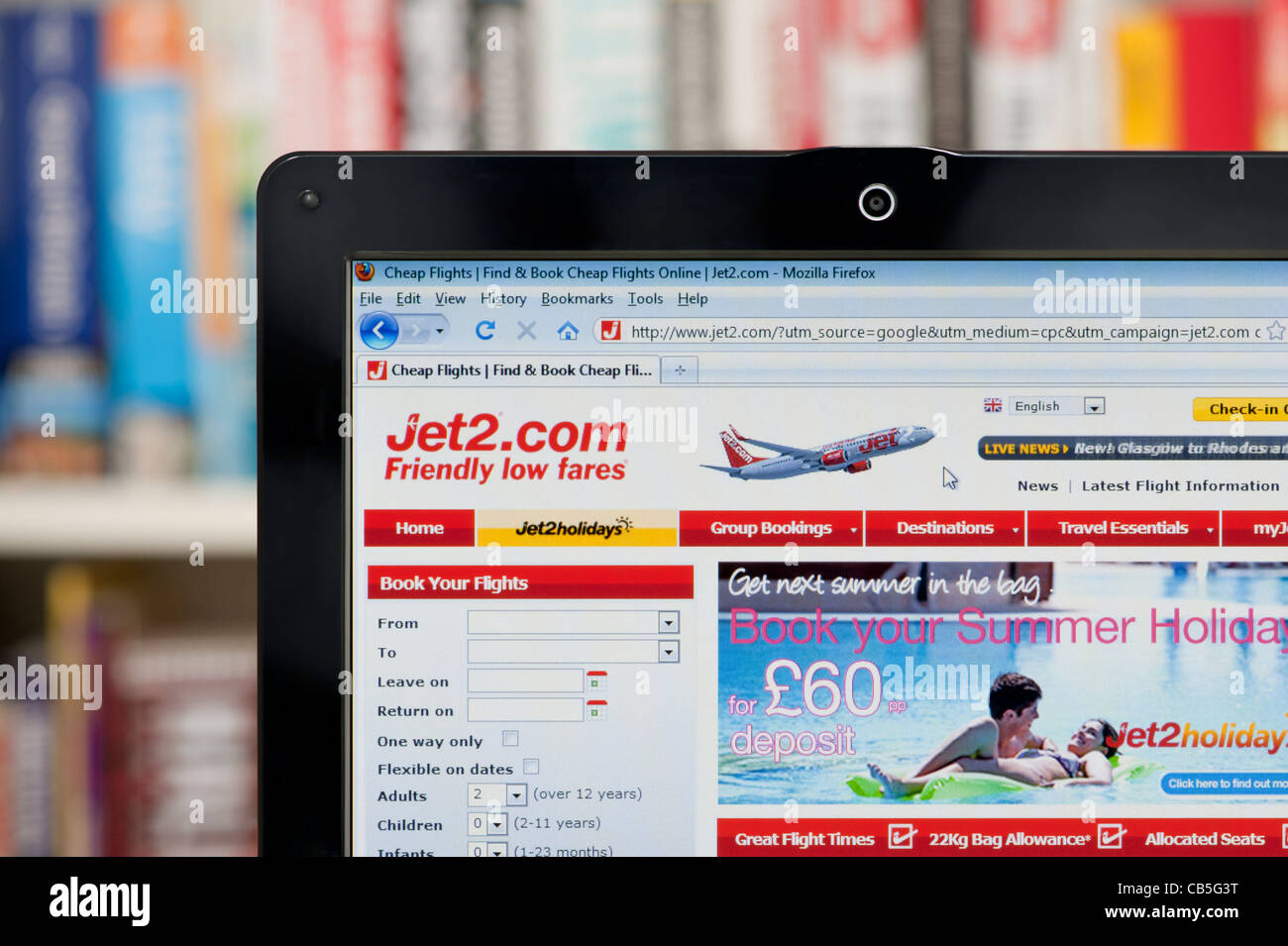 The Jet2.com website shot against a bookcase background (Editorial use only: print, TV, e-book and editorial website). Stock Photo