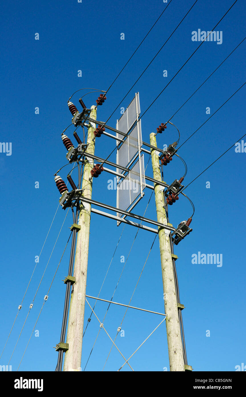 High tension electricity cables supported by wooden poles Stock Photo