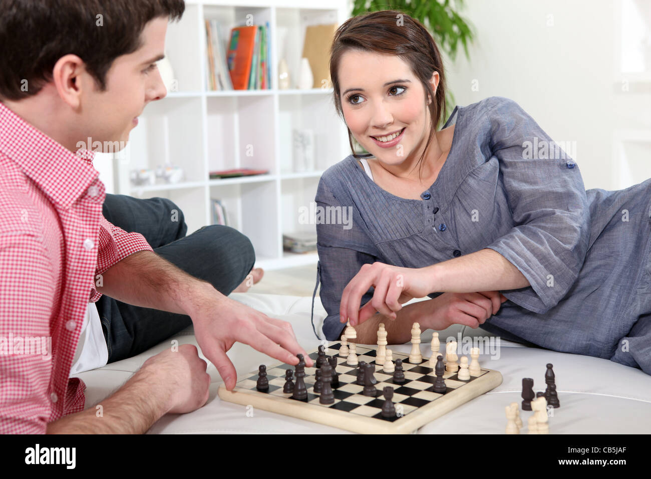 We like playing chess. Фото девушка играет в шахматы с мужчиной.