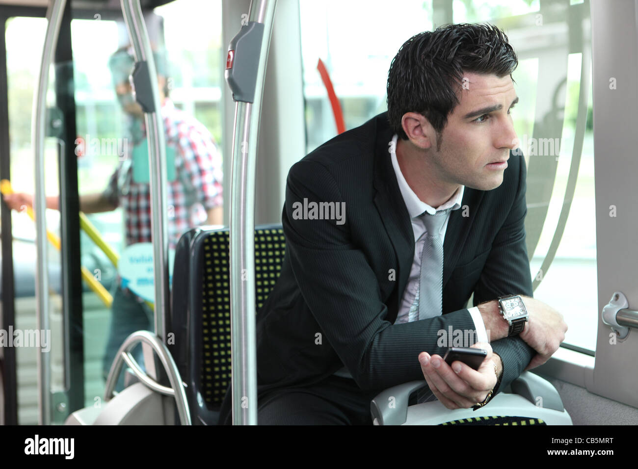 Man riding tram to work Stock Photo