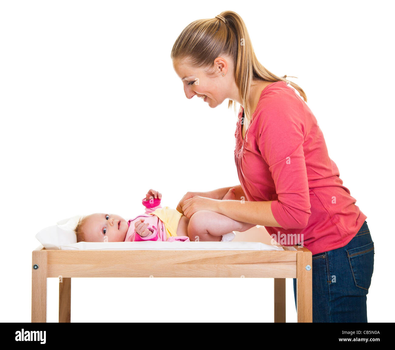 Mother changing child's diaper on nursery table isolated on white Stock Photo