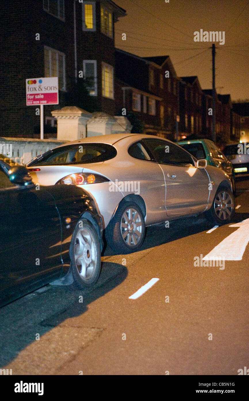 careless and dangerous car parking on an urban street at night Stock Photo