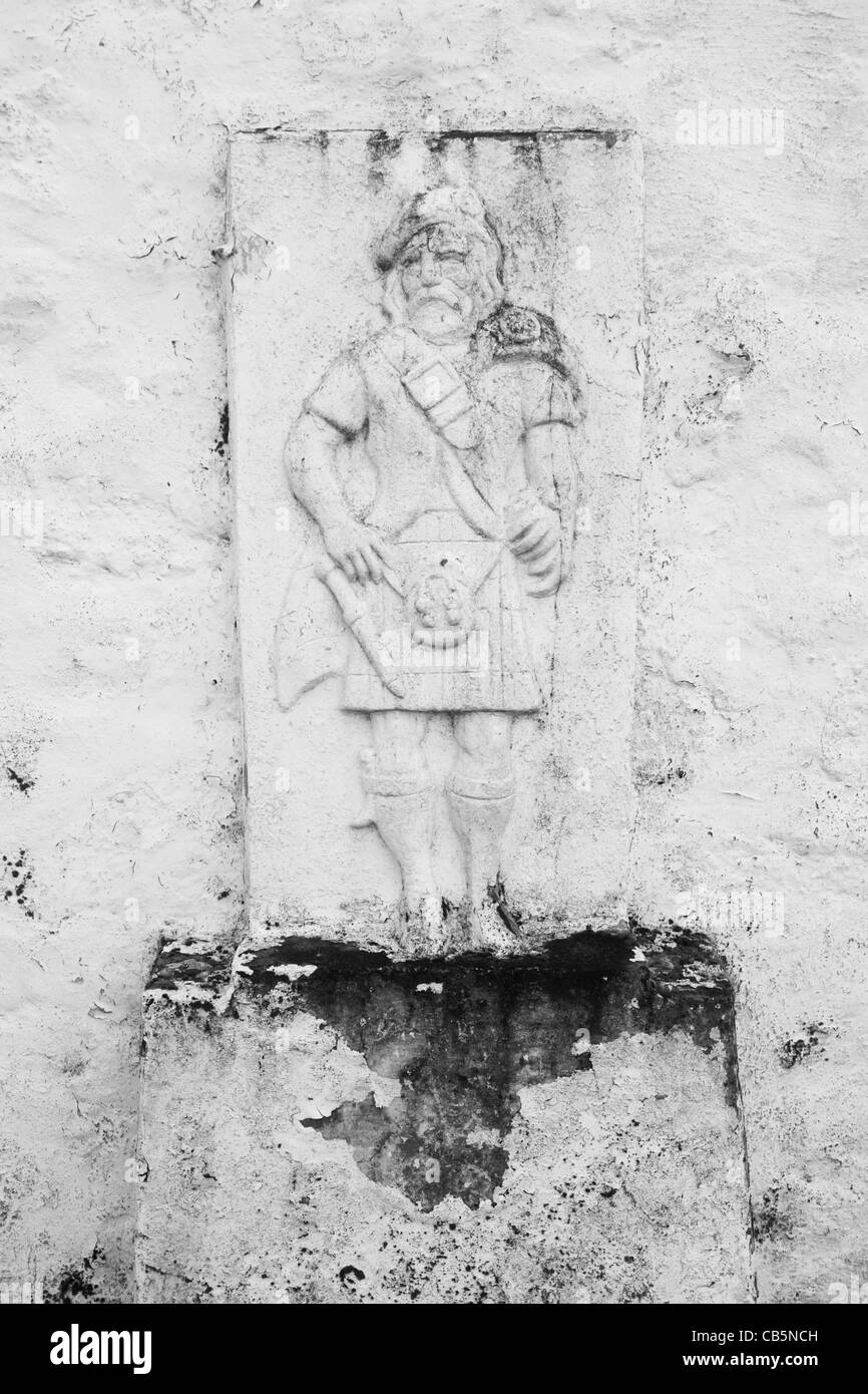 Highlander effigy on an outside wall of Old Ferry House, now a remote self-catering house at Grasspoint, Loch Don, Isle of Mull. Stock Photo