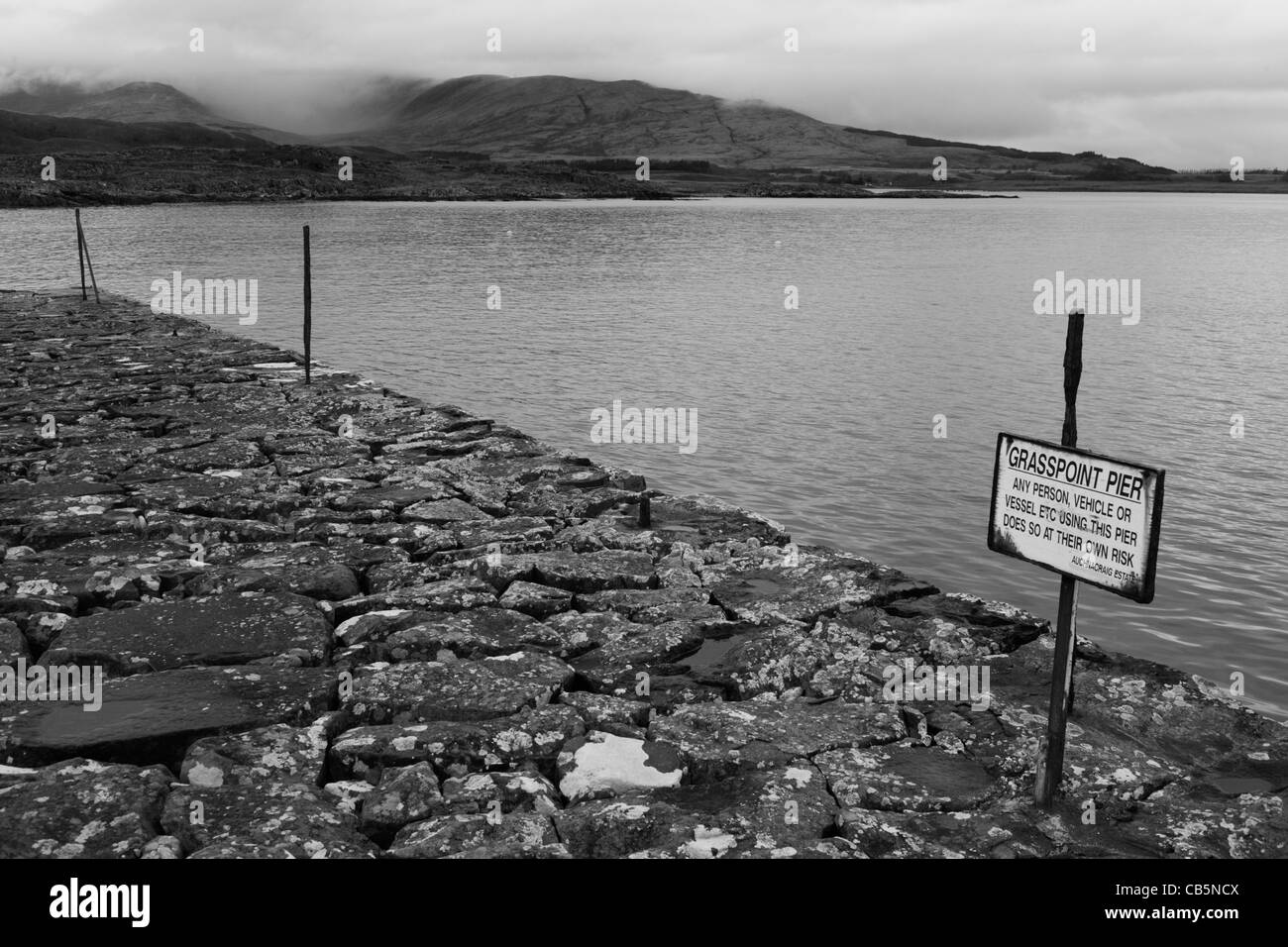 Disused sign and pier stones near Old Ferry House, now a remote self-catering house at Grasspoint, Loch Don Isle of Mull. Stock Photo
