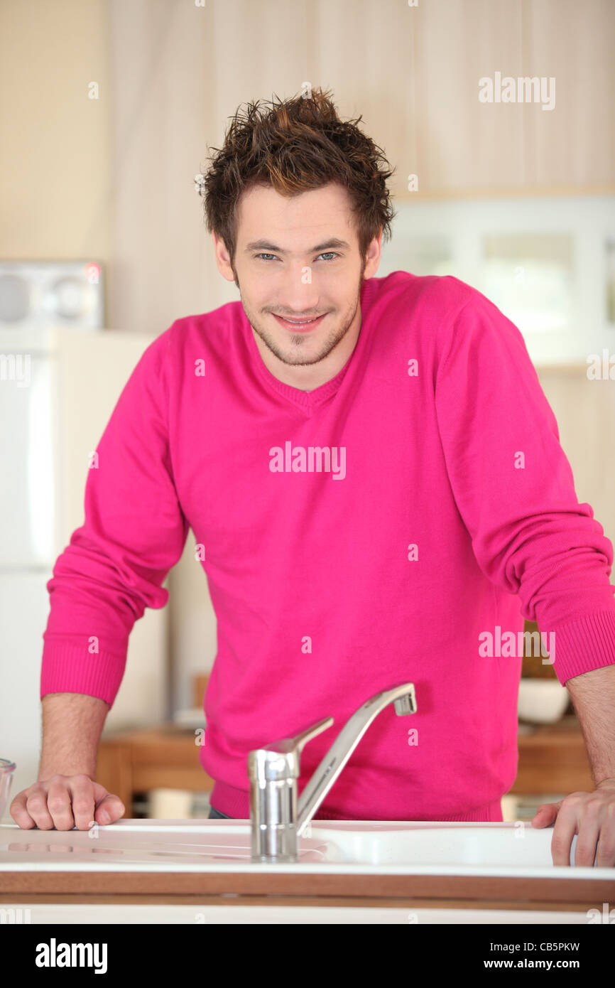 Man standing in front of his kitchen sink Stock Photo