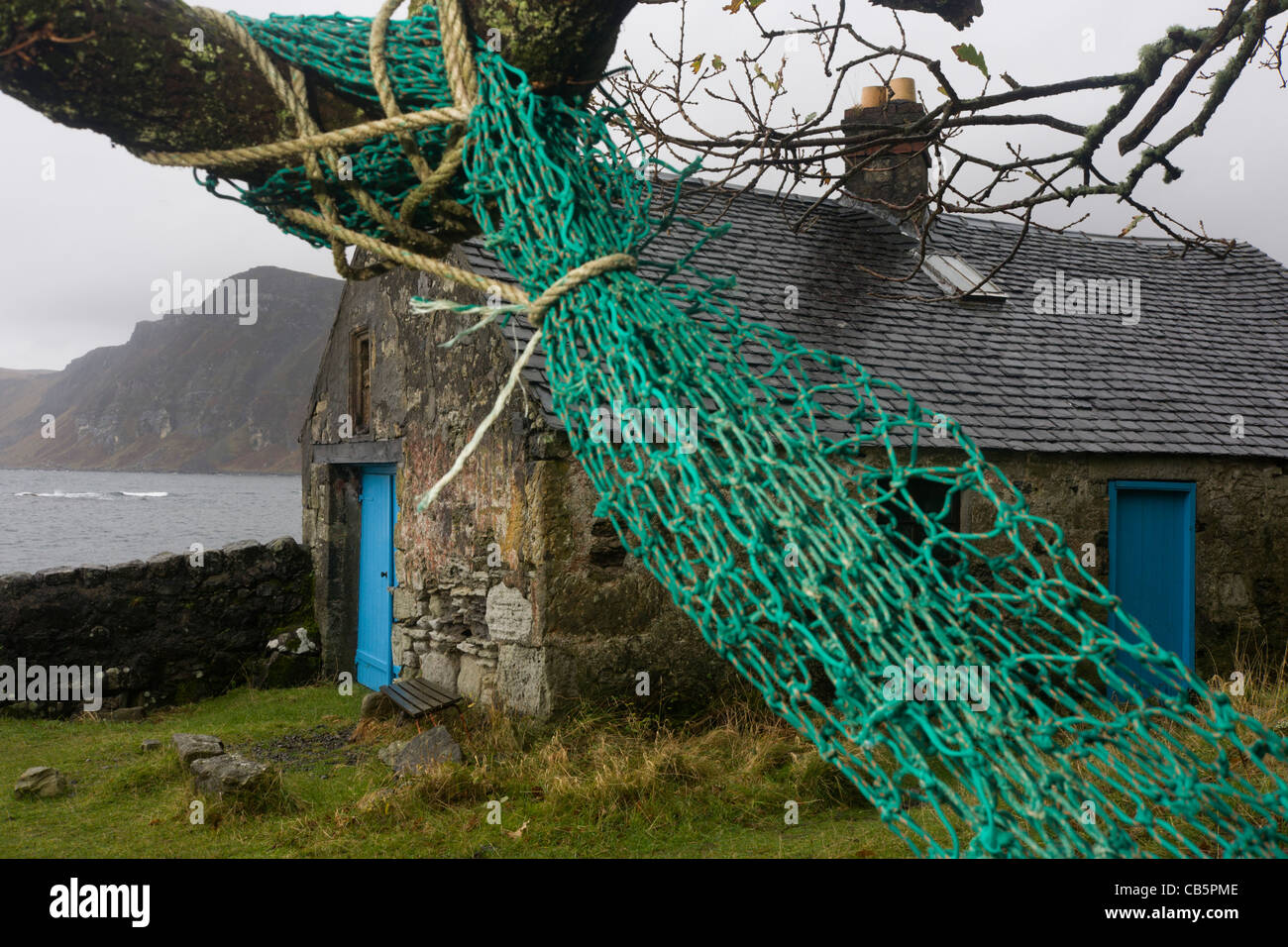 Old cottage and nets at Carsaig Bay fishing pier, Isle of Mull, Scotland. Stock Photo