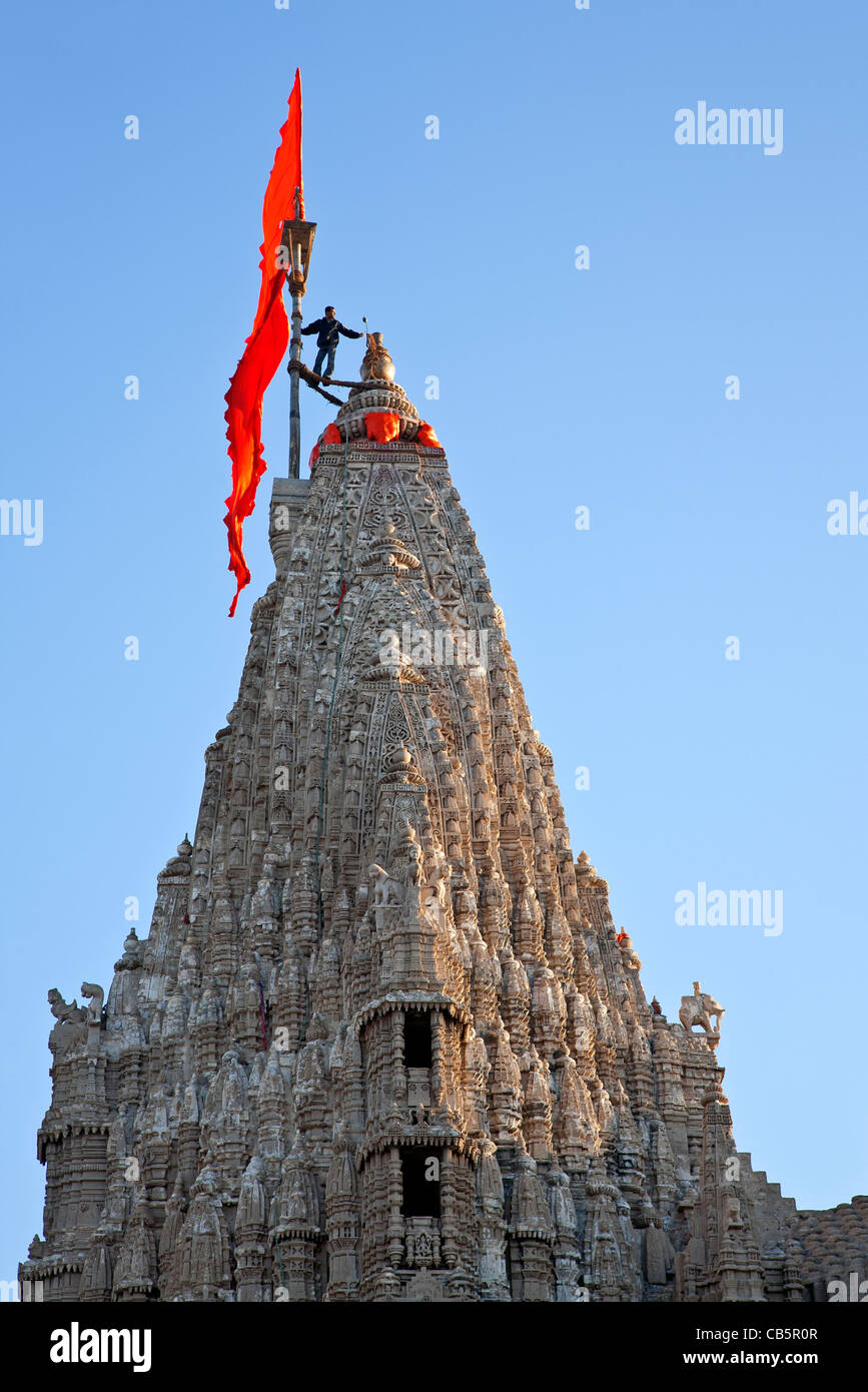 Man changing the flag at the top  of Dwarakadheesh Temple. Dwarka. Gujarat. India Stock Photo