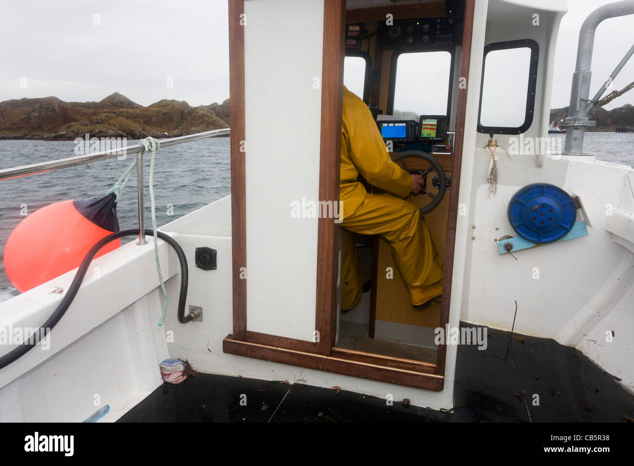 Local fisherman Neil Cameron sails towards his creel location to be filled with Velvet and Green Crab off Isle of Mull. Stock Photo