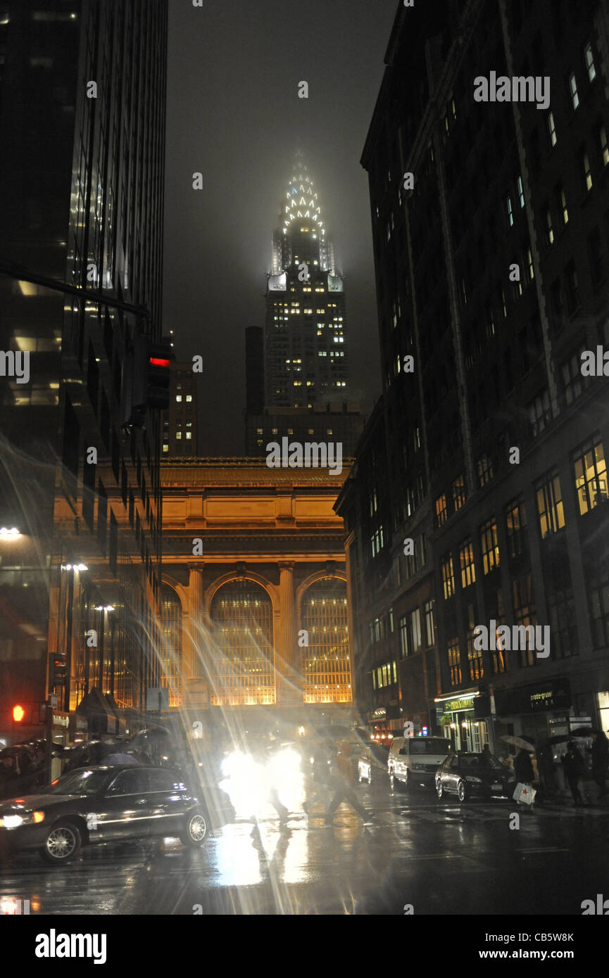 Like a scene from Gotham City the Chrysler Building lit up at night on wet rainy evening Manhattan New York NYC USA Stock Photo