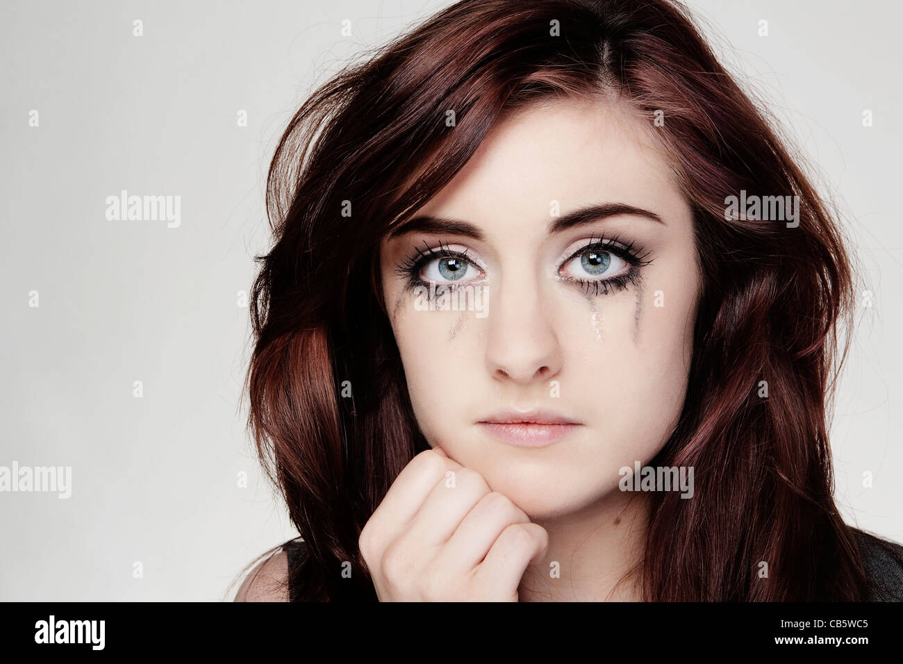 close up portrait of a young woman crying make up running down face