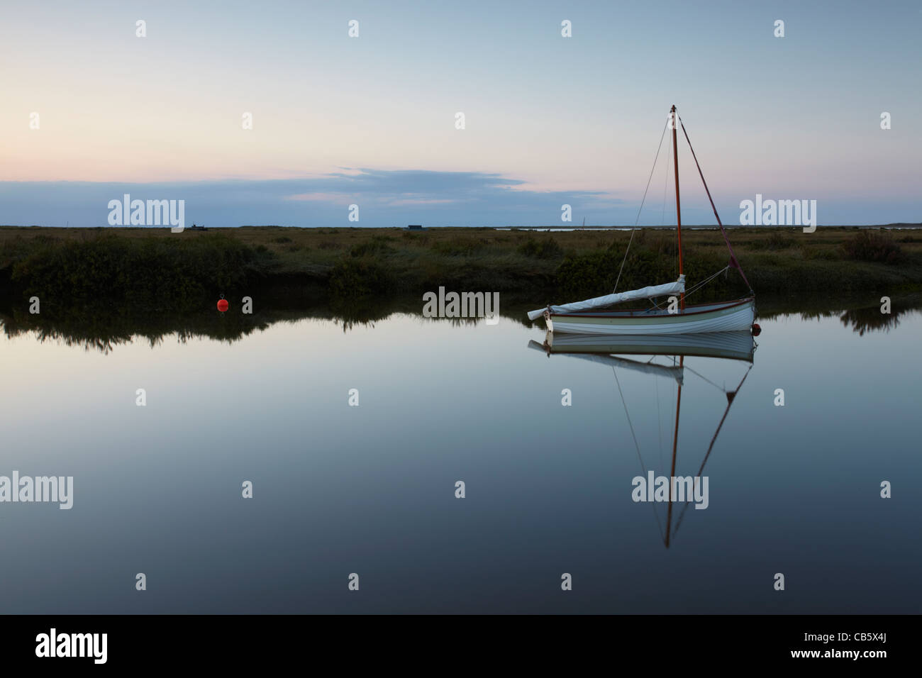 A lone boat amongst a tidal channel at Stiffkey on the North Norfolk Coast Stock Photo