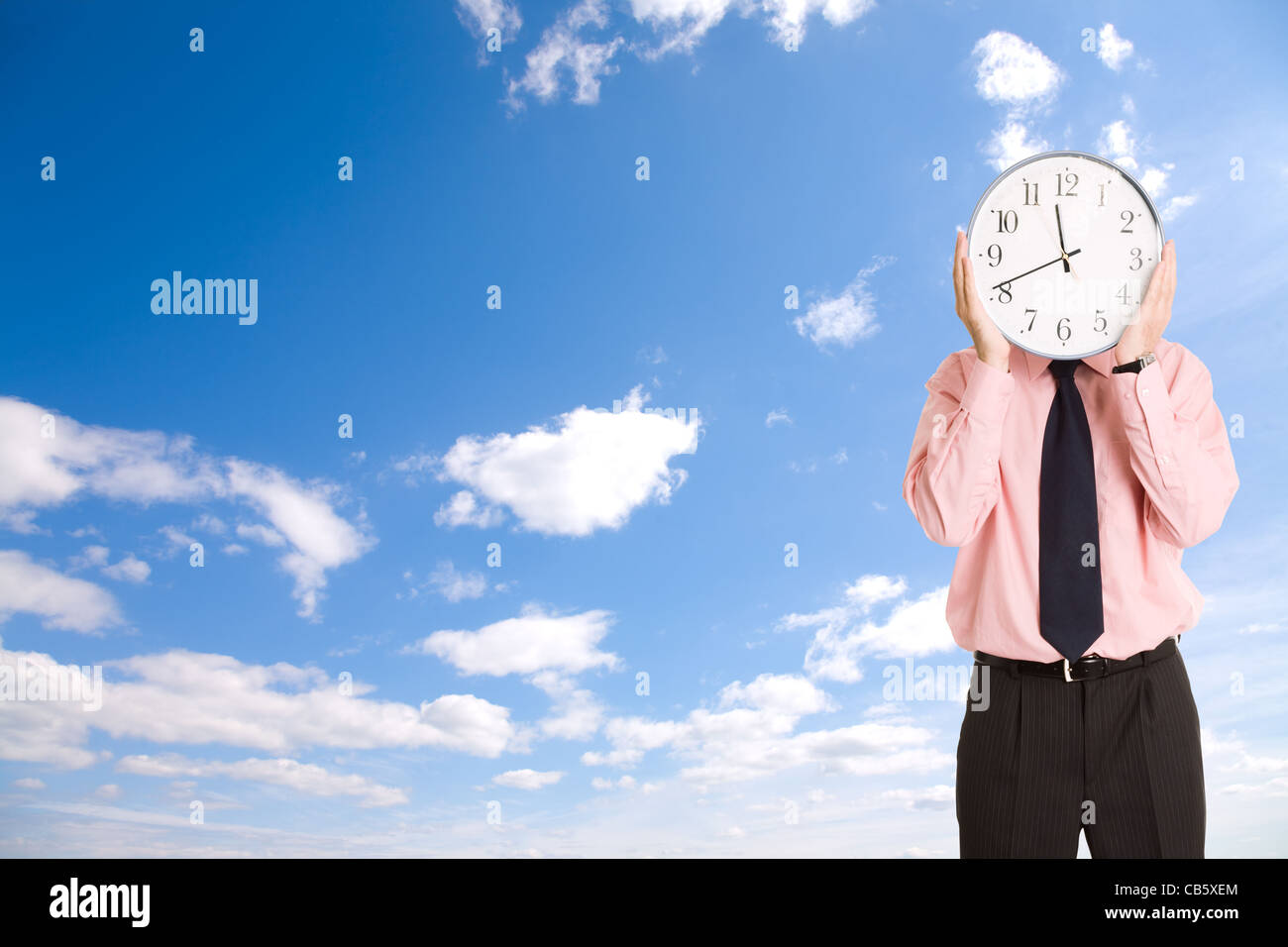 businessman with clock on blue sky background Stock Photo