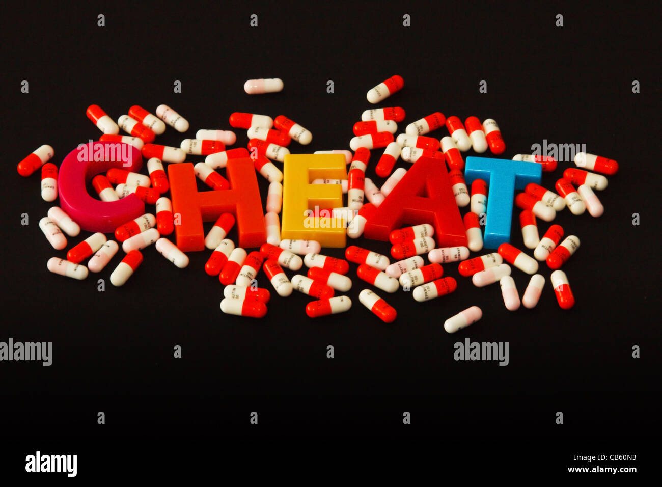 'Cheat' spelt with magnetic letters surrounded by drug capsules Stock Photo
