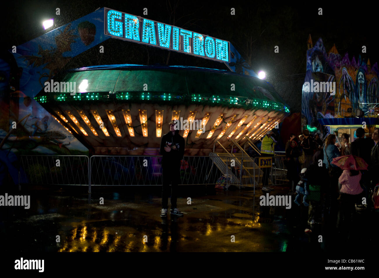 Customers wait in the Rain to Ride the GRAVITRON Amusment Park Ride- sci fi Stock Photo