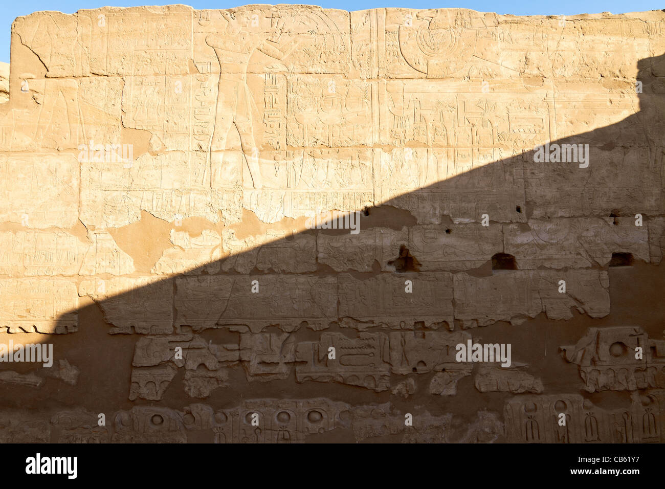Part of a wall with hieroglyphs and diagonal shadow, as background