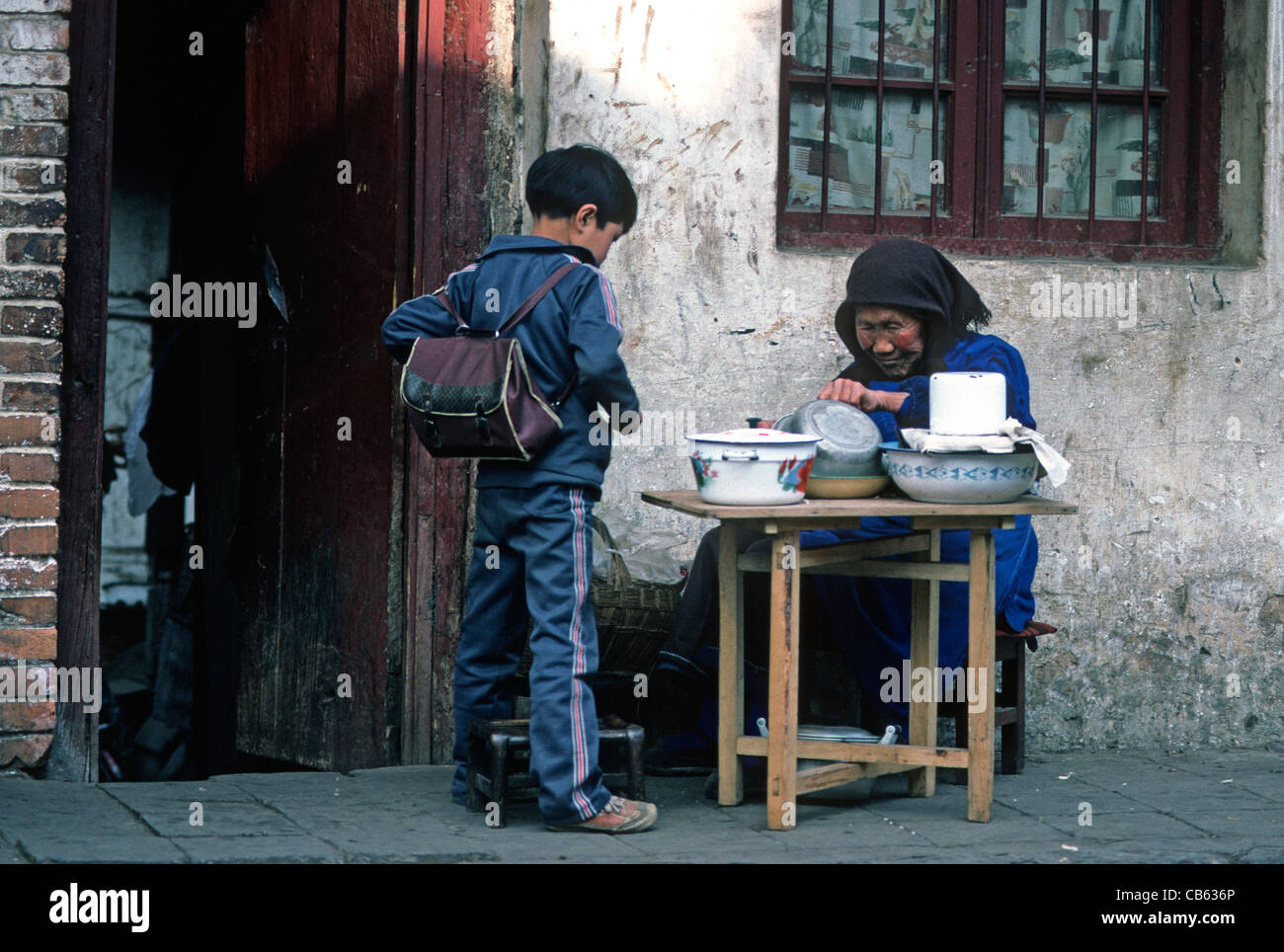 Boy buying food from old woman Kunming Yunnan China Stock Photo - Alamy