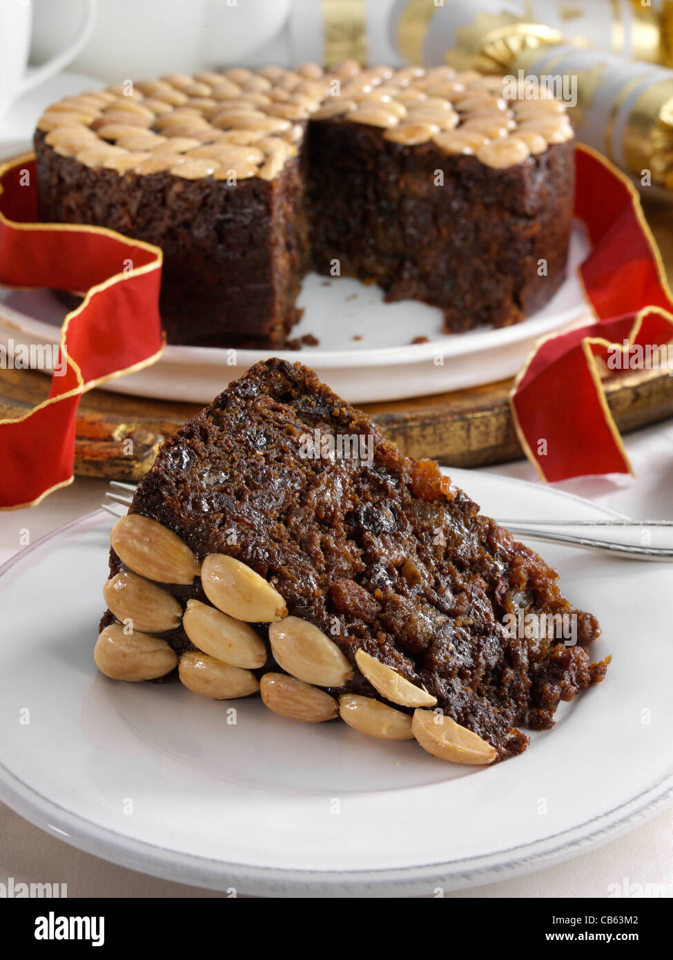 UK Christmas cake with a slice in front Stock Photo