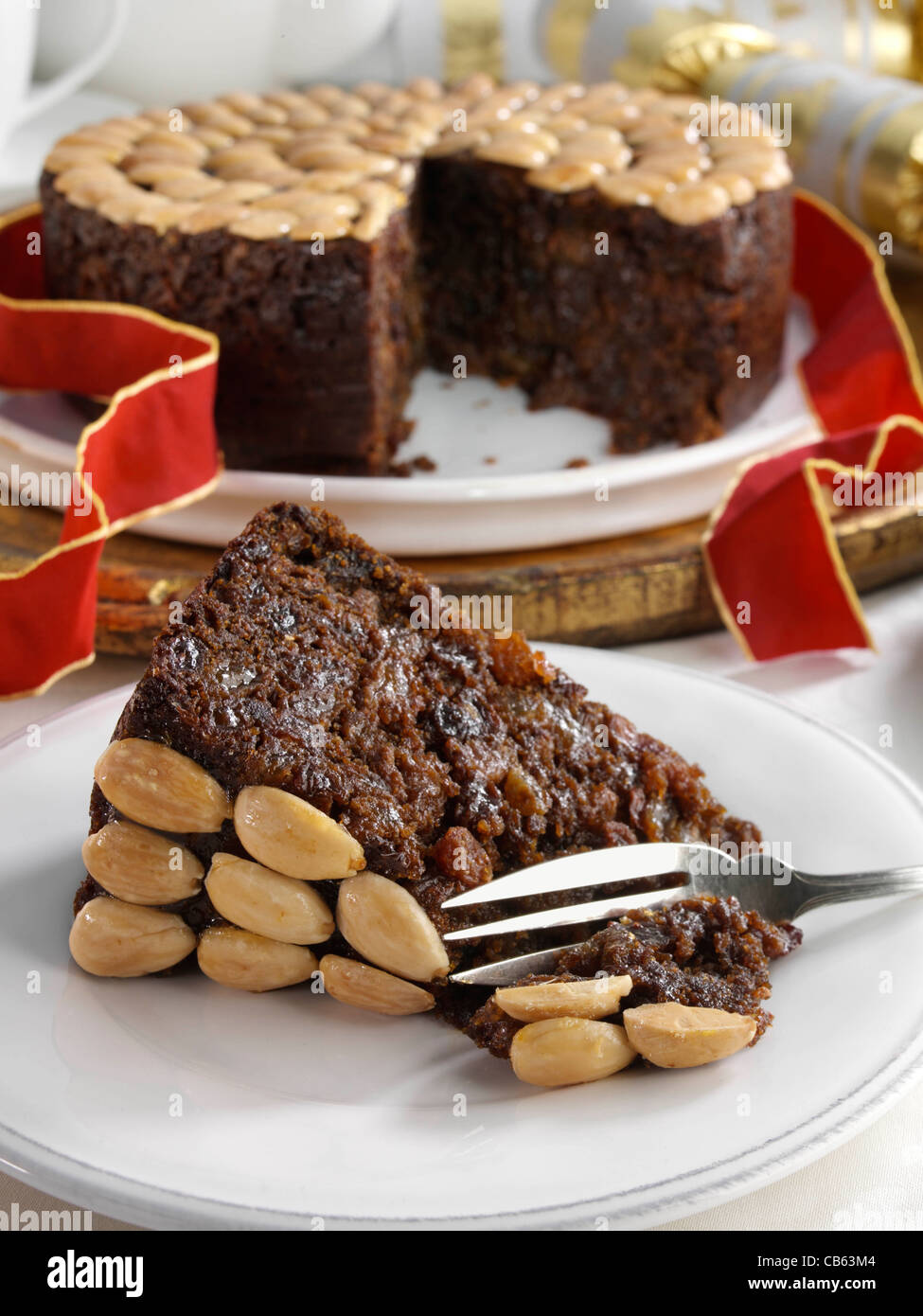 UK Christmas cake with a slice in front Stock Photo