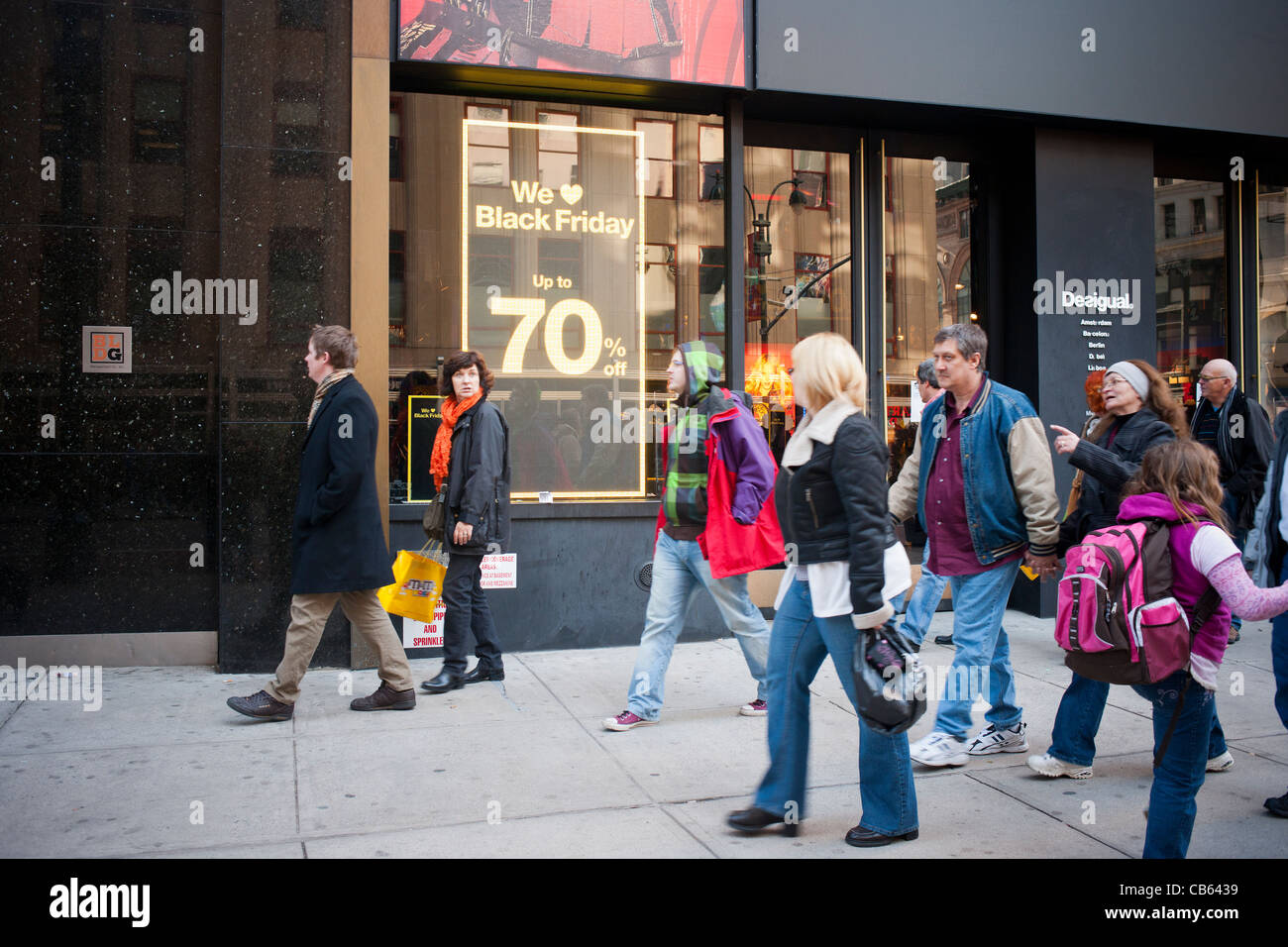 Shoppers outside the Desigual store advertising their Black Friday sales Stock Photo