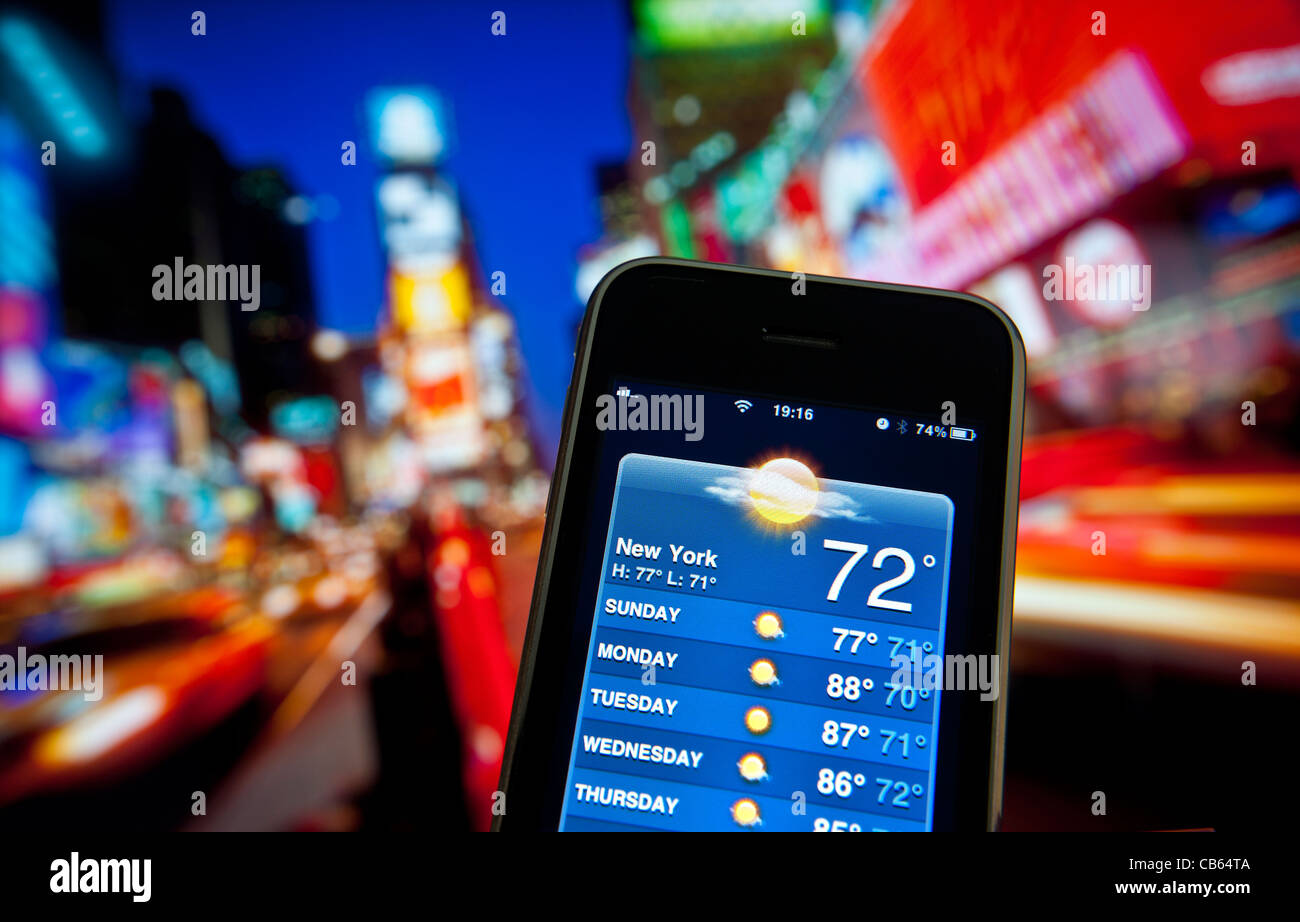 Times Square at dusk with Apple iPhone with screen app forecasting week