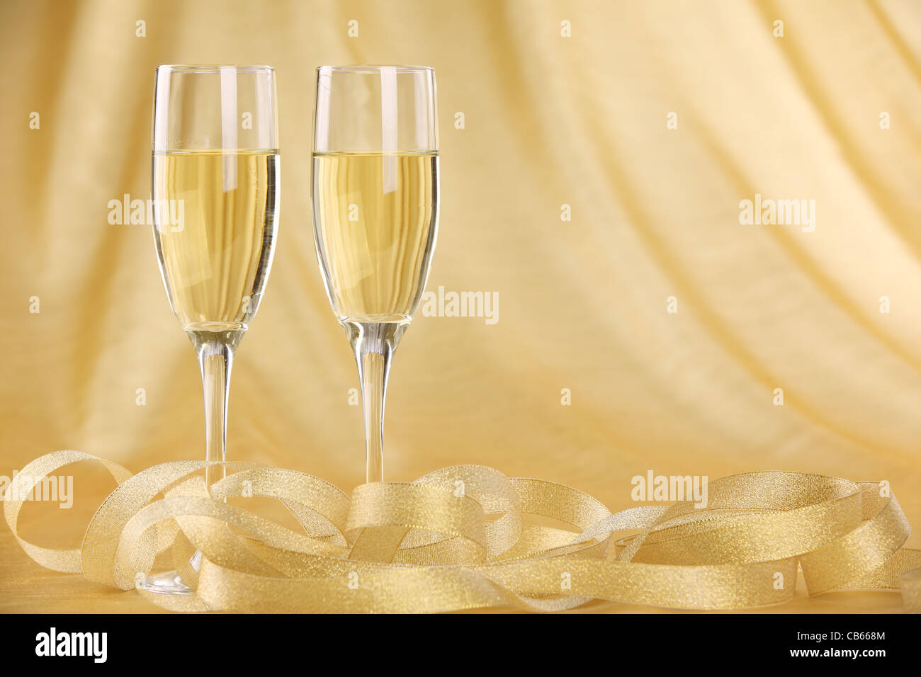 Glasses of champagne with golden ribbon. Stock Photo