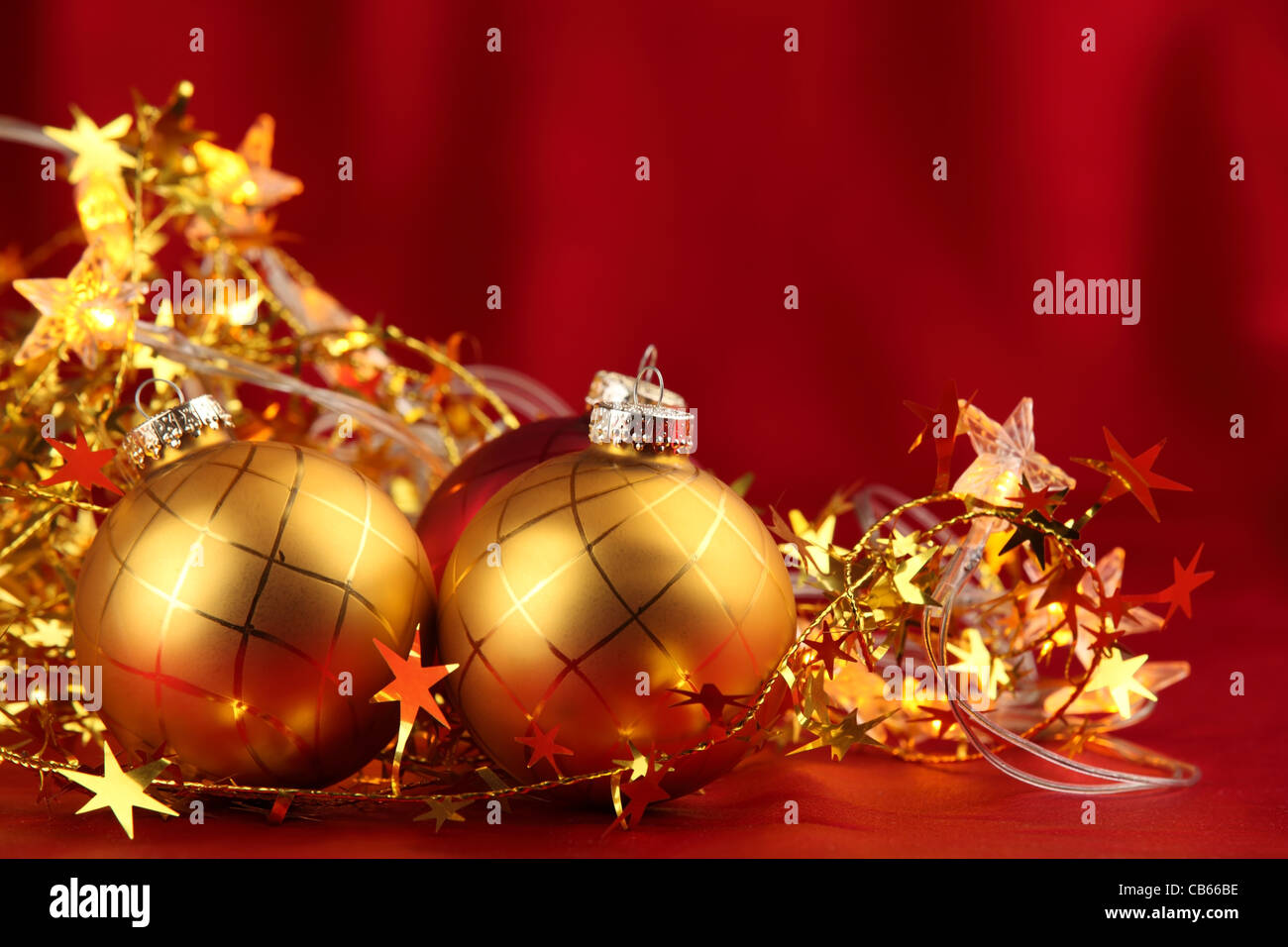 Closeup of golden balls and glitter star on red background Stock Photo ...