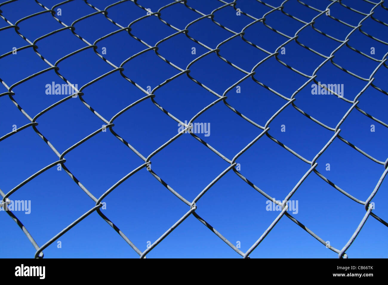 chain link fence mesh with blue sky background Stock Photo
