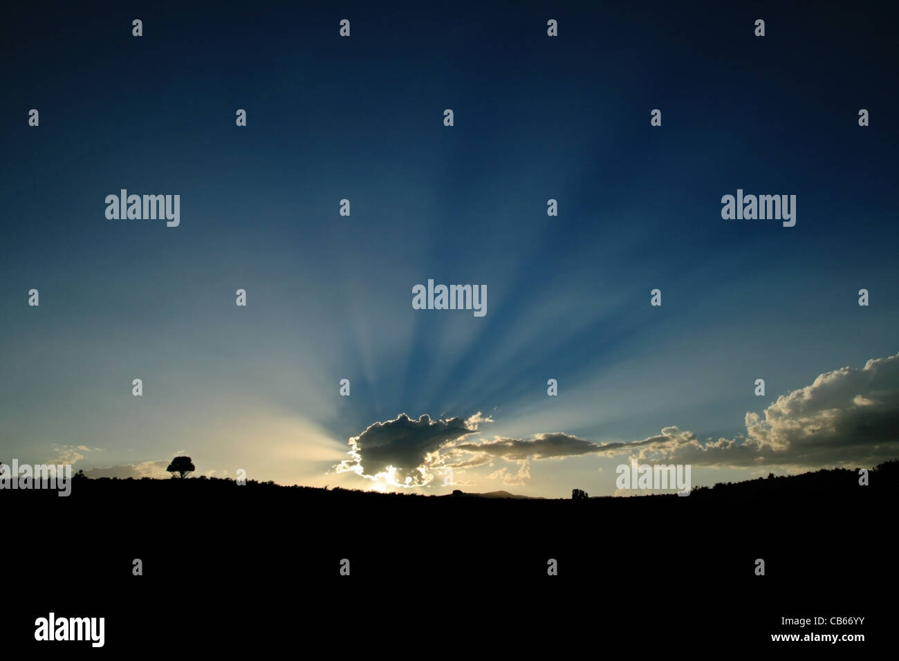 sun rays emerge from behind a cloud Stock Photo