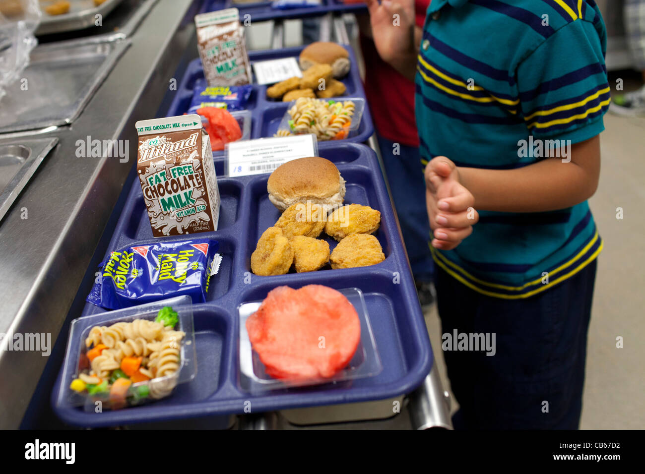 A student makes a selection in an elementary school lunch line. Stock Photo