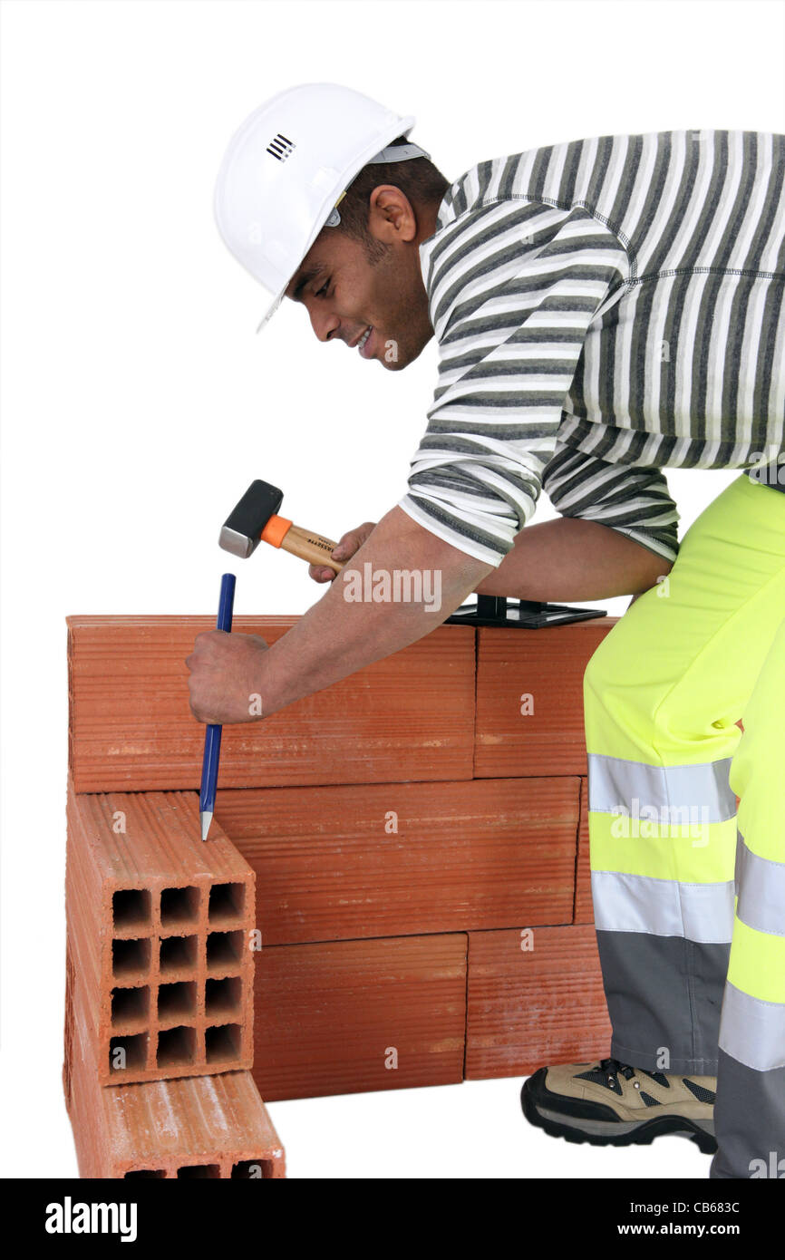 Bricklayer using a hammer and chisel Stock Photo Alamy