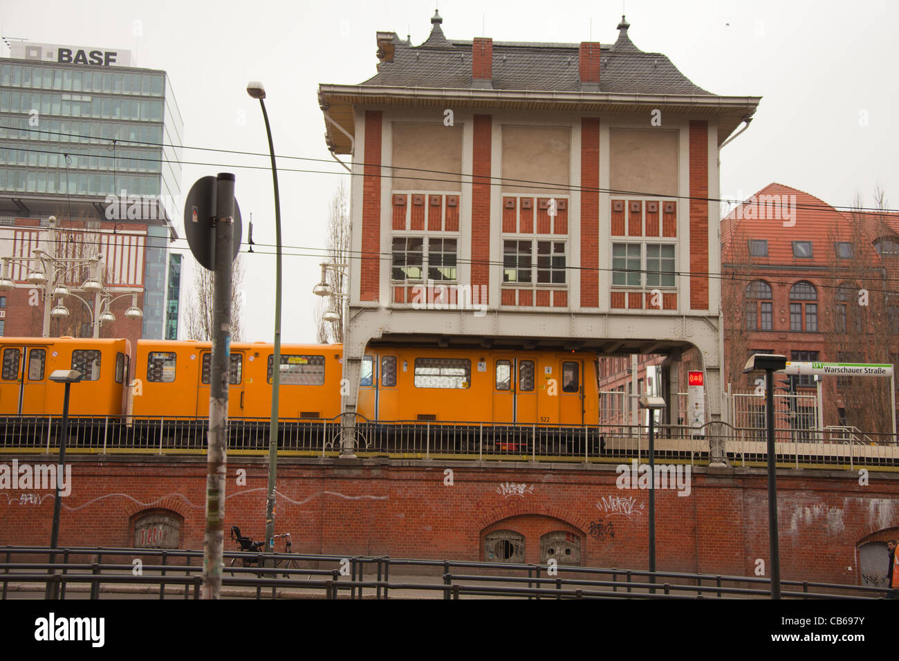 Berlin, Germany, March 05, 2011: Warschauer Straße U-bah train station - yellow electric train under the house that build on top of medium-capacity rail transport system rail line Stock Photo