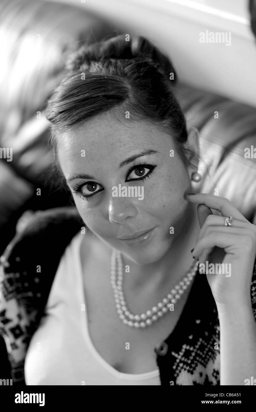 Young woman in twenties 20s wearing pearl necklace and earings with hair up like Audrey Hepburn style black and white photo Stock Photo