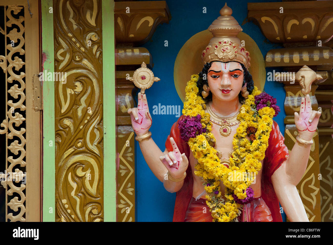 Garlanded Vishnu statue on a colourful Hindu Hanuman temple. Andhra Pradesh, India Stock Photo