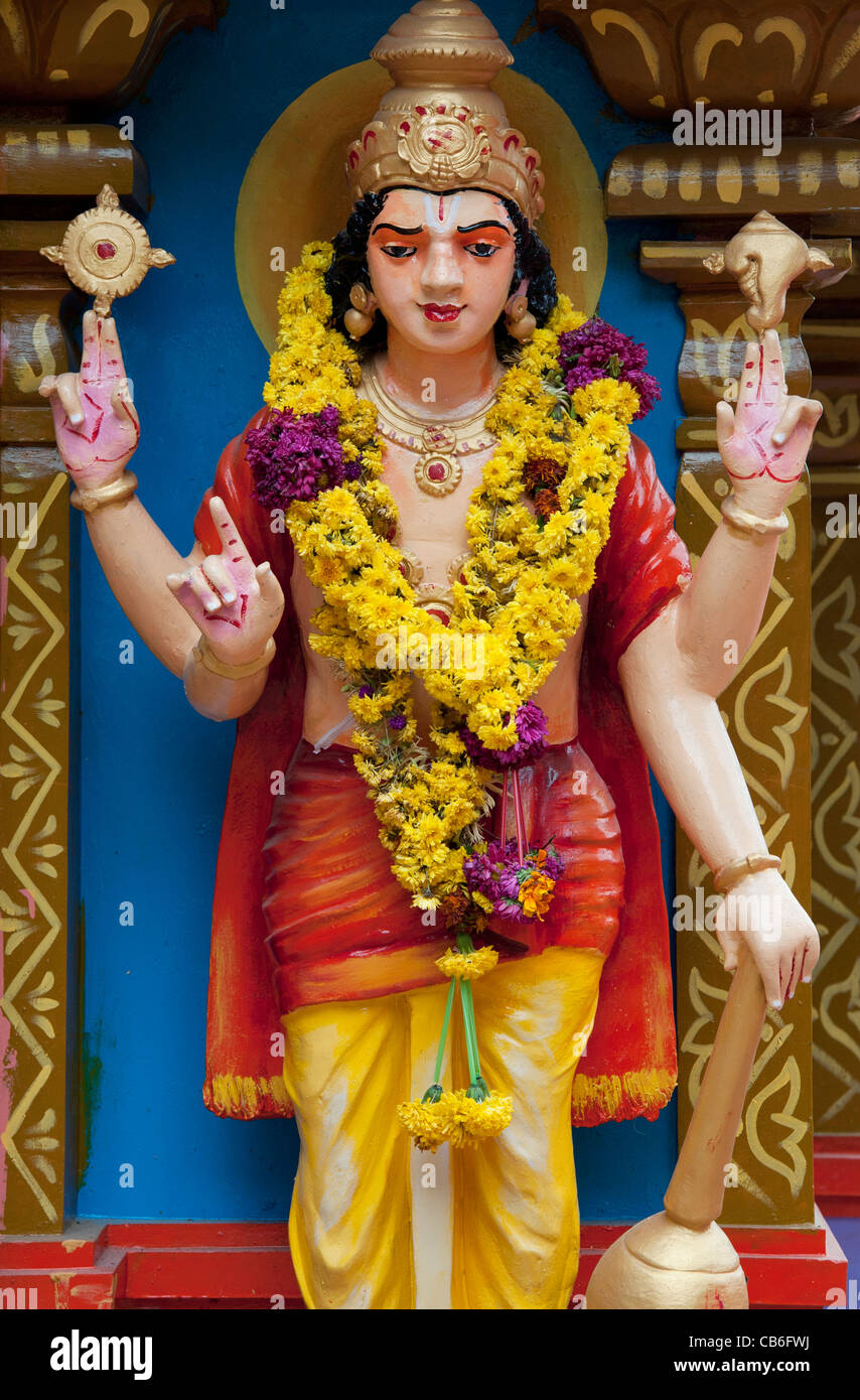 Garlanded Vishnu statue on a colourful Hindu Hanuman temple. Andhra Pradesh, India Stock Photo