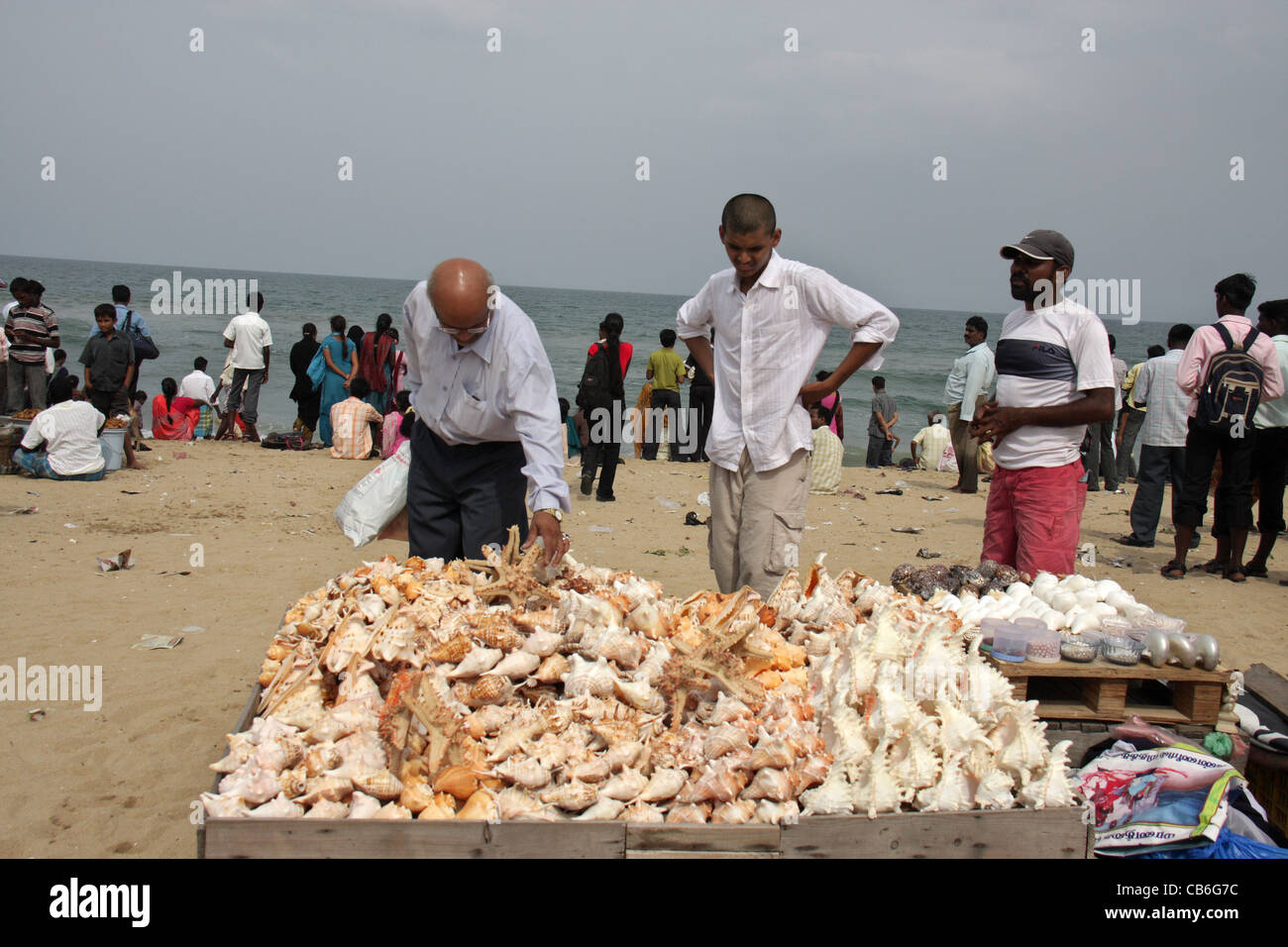 tourists purchasing sea shells and marine curios from a vendor in
