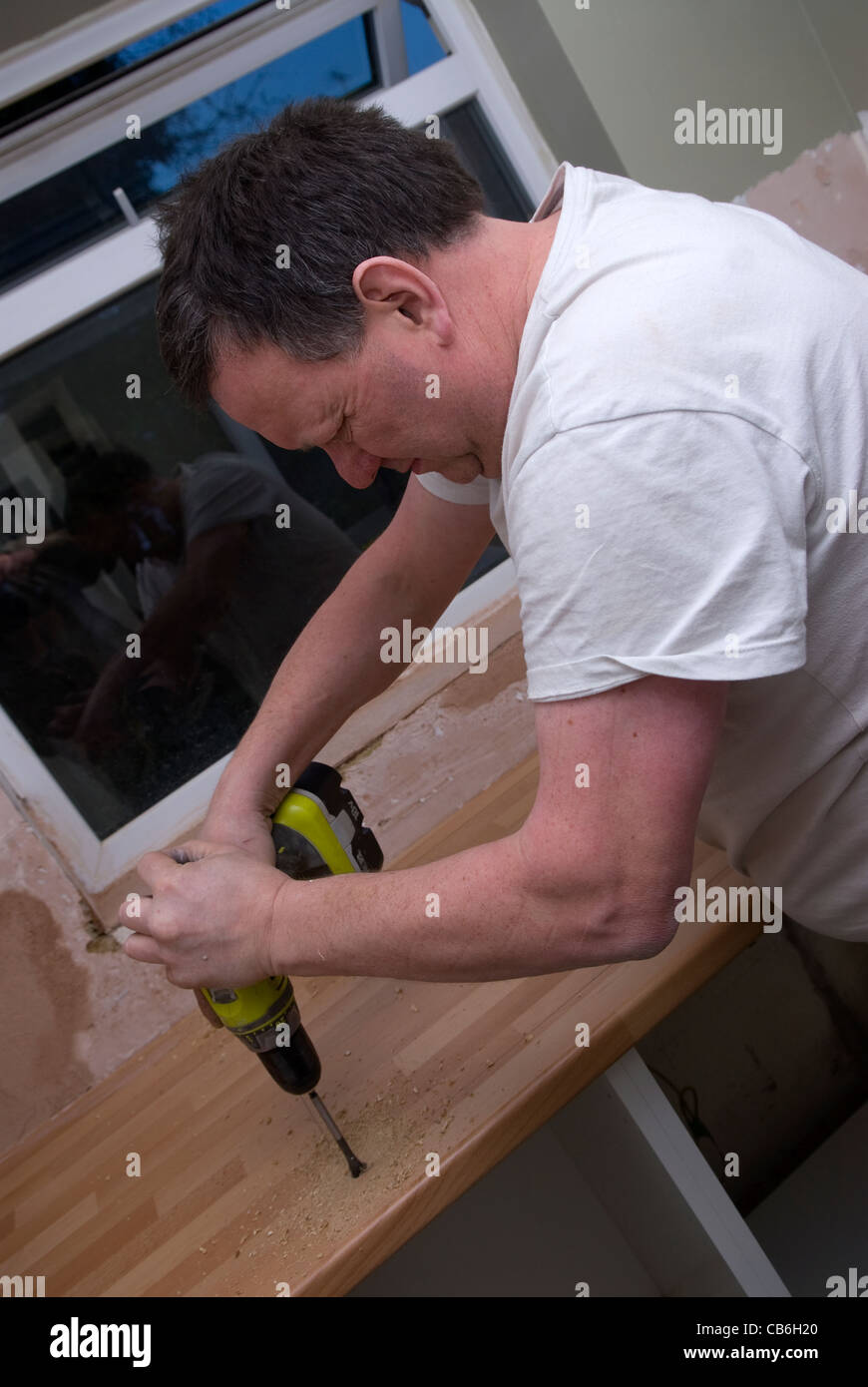 Tradesman using a drill in preparation for cutting out worktop for