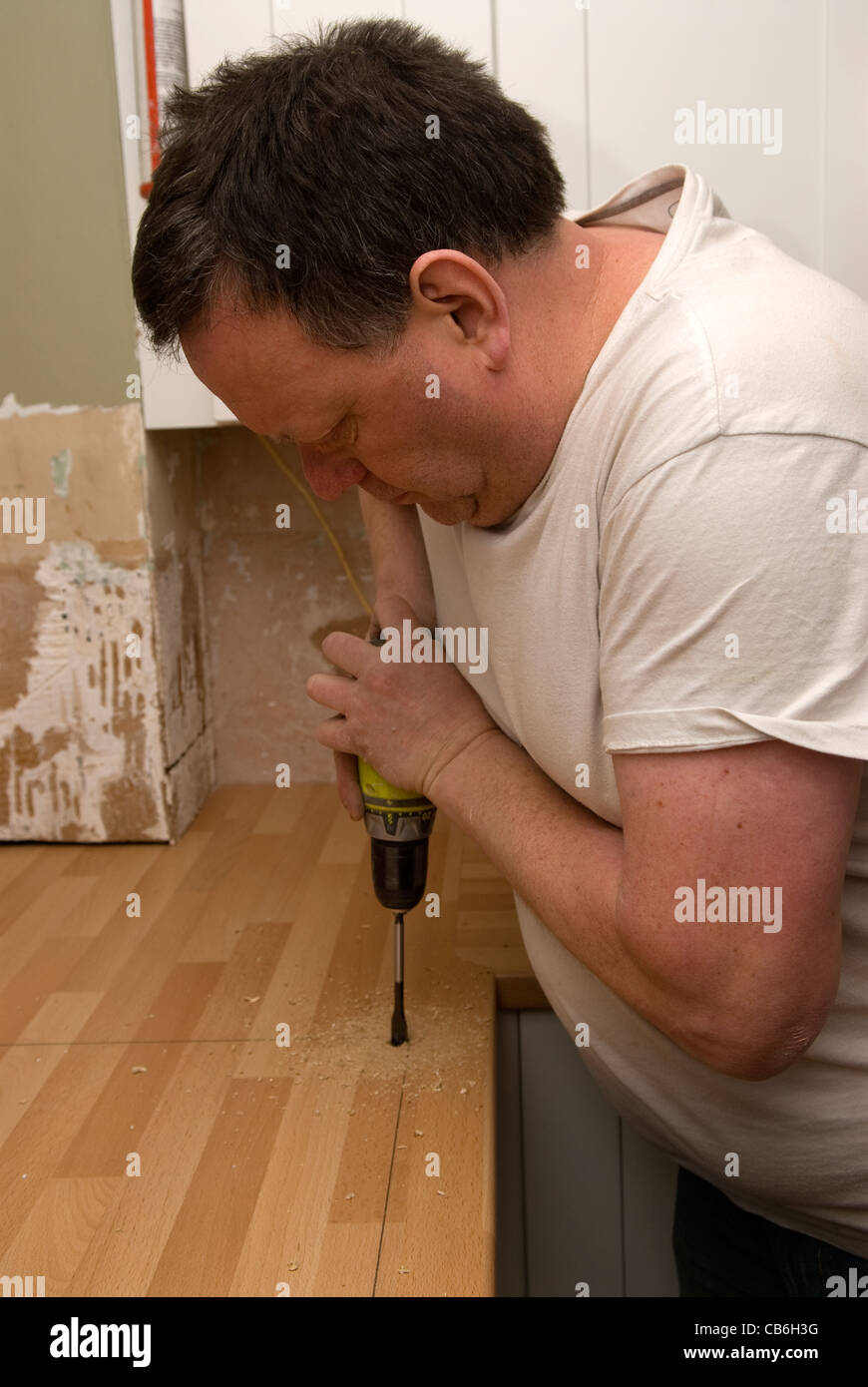 Tradesman using a drill in preparation for cutting out worktop for