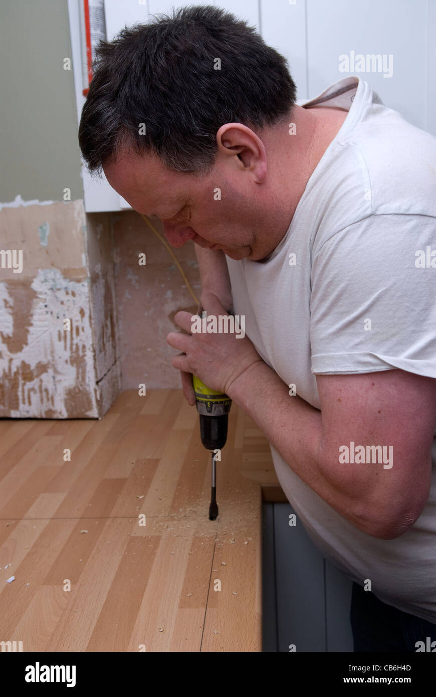 Tradesman using a drill in preparation for cutting out worktop for